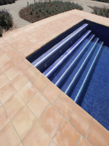 Escaleras de piscina con suelo de barro cocido en terraza exterior