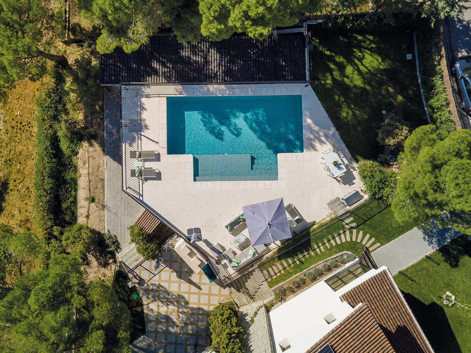 Ejemplo de baldosas de gres porcelánico antideslizante instaladas alrededor de una piscina moderna.